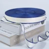 A flat lay of customized woven brand logo Jacquard Webbing Tape in various colors and widths, displayed on books.
