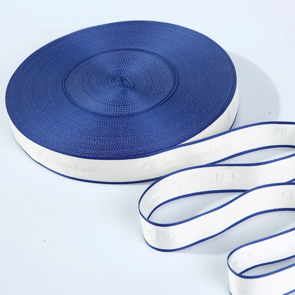 A stack of neatly rolled custom brand logo jacquard webbing tapes showcasing clean typography and high-tensile woven craft.