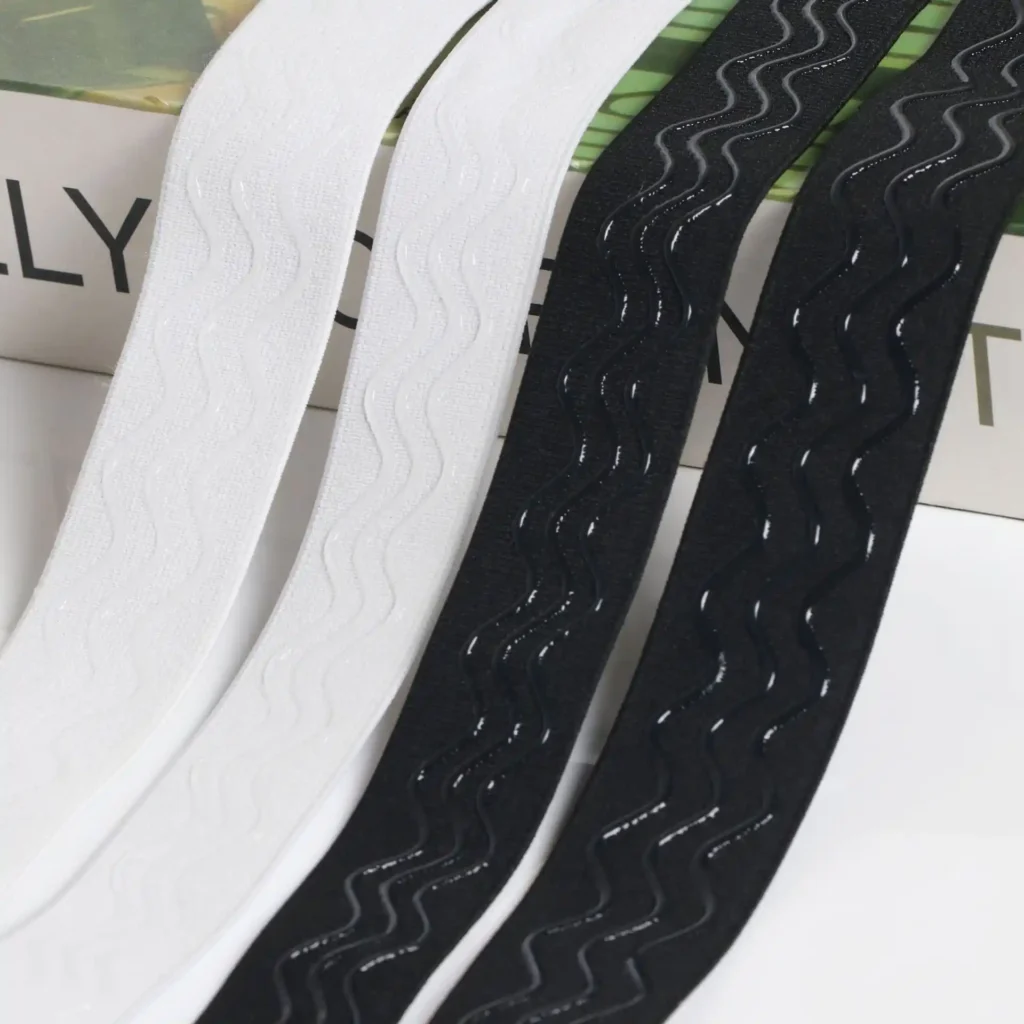 Soft silicone backed jacquard elastic band showing custom woven "SOFTFLEX" logo on the front and wavy anti-slip liquid silicone grip on the reverse side, featuring an OEKO-TEX Standard 100 label.